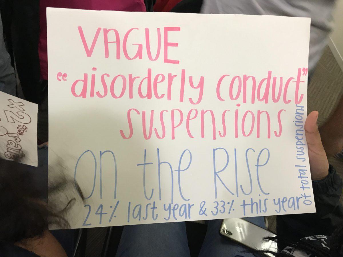 TWU youth member holds up poster criticizing subjective offense suspensions in ACPS at the April 25 School Board meeting.