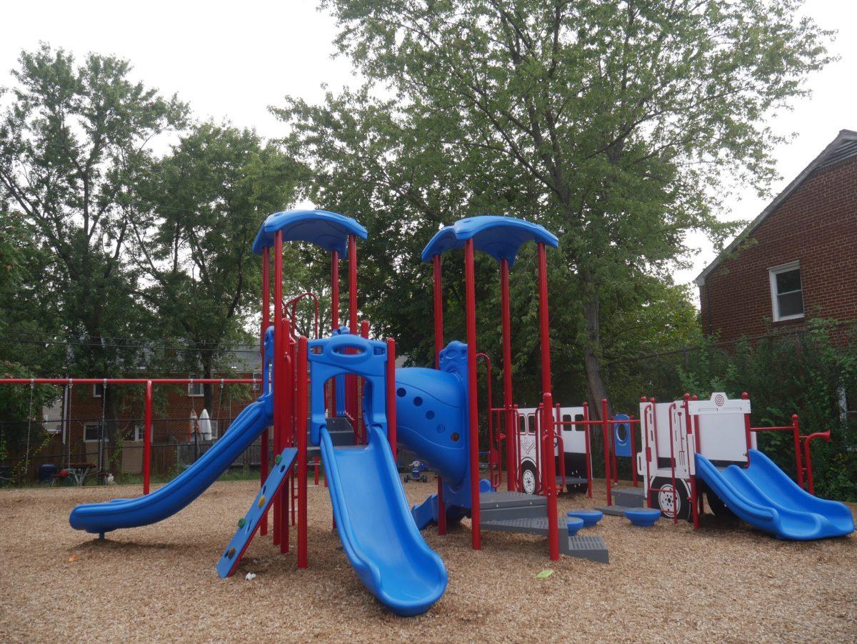 The+Woodbine+Tot+Lot+features+a+play+structure+with+slides%2C+a+tunnel%2C+monkey+bars%2C+swings%2C+and+a+seesaw.+