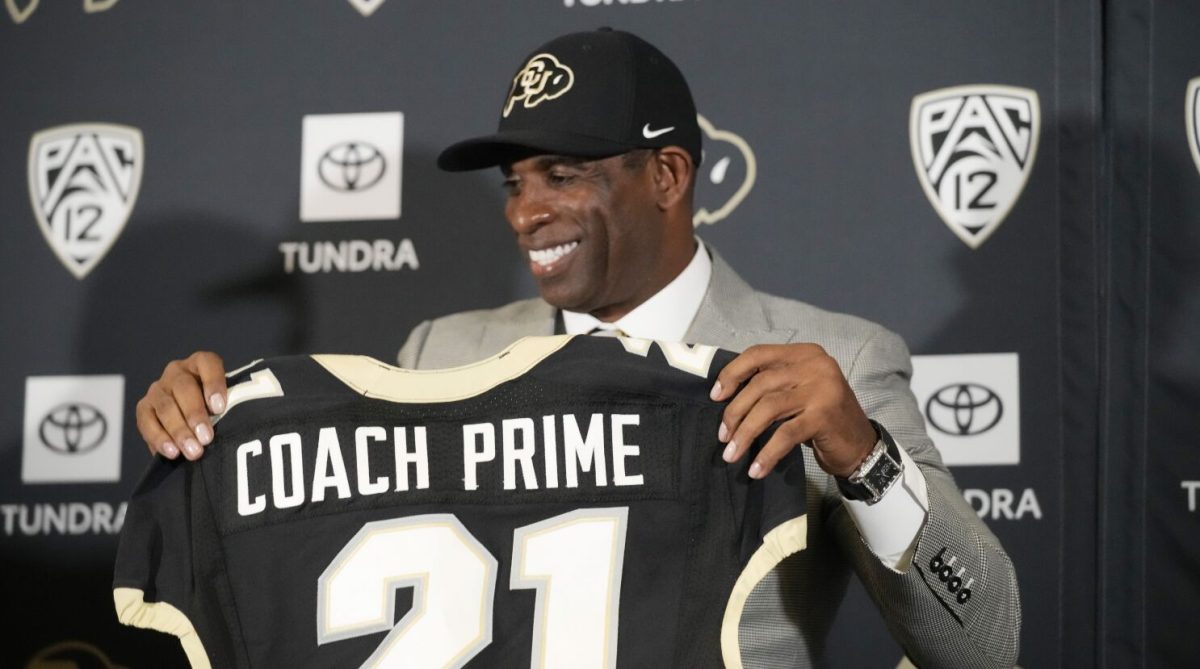 Deion+Sanders+holding+up+Colorado+jersey+the+day+he+had+his+first+press+conference.