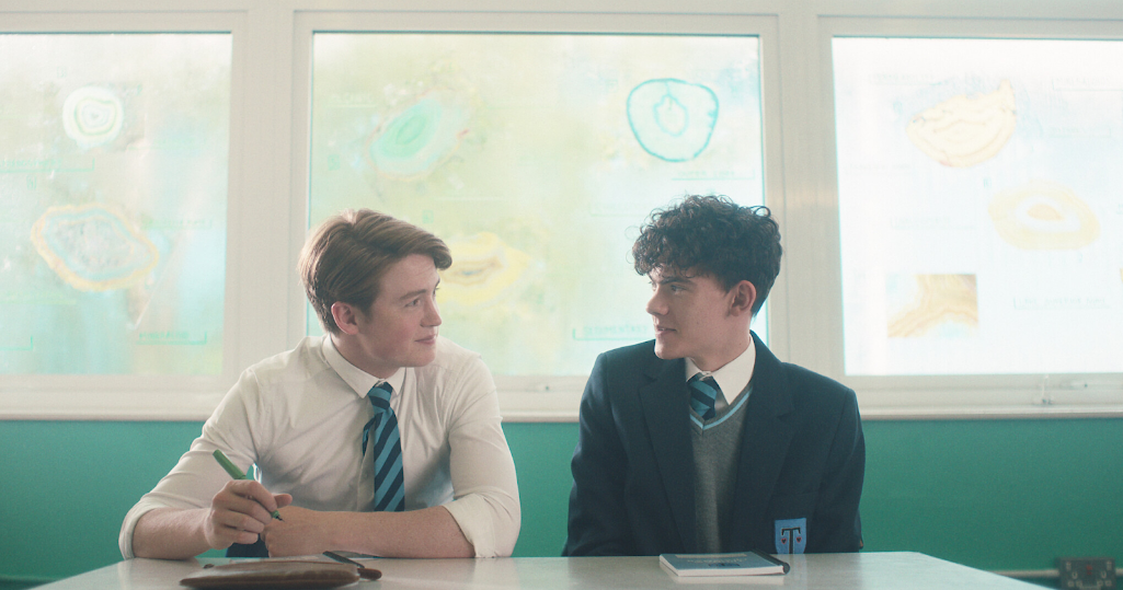 Nick, played by British actor Kit Connor, and Charlie, played by Manx actor Joe Locke, stare at each other during class time. / Netflix