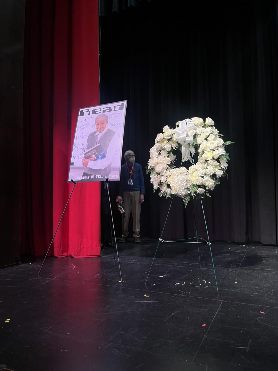 A picture of Louis Kokonis and a wreath displayed on stage.