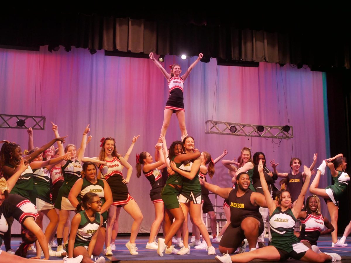 The Jackson and Truman High School cheerleaders dance together in unison.