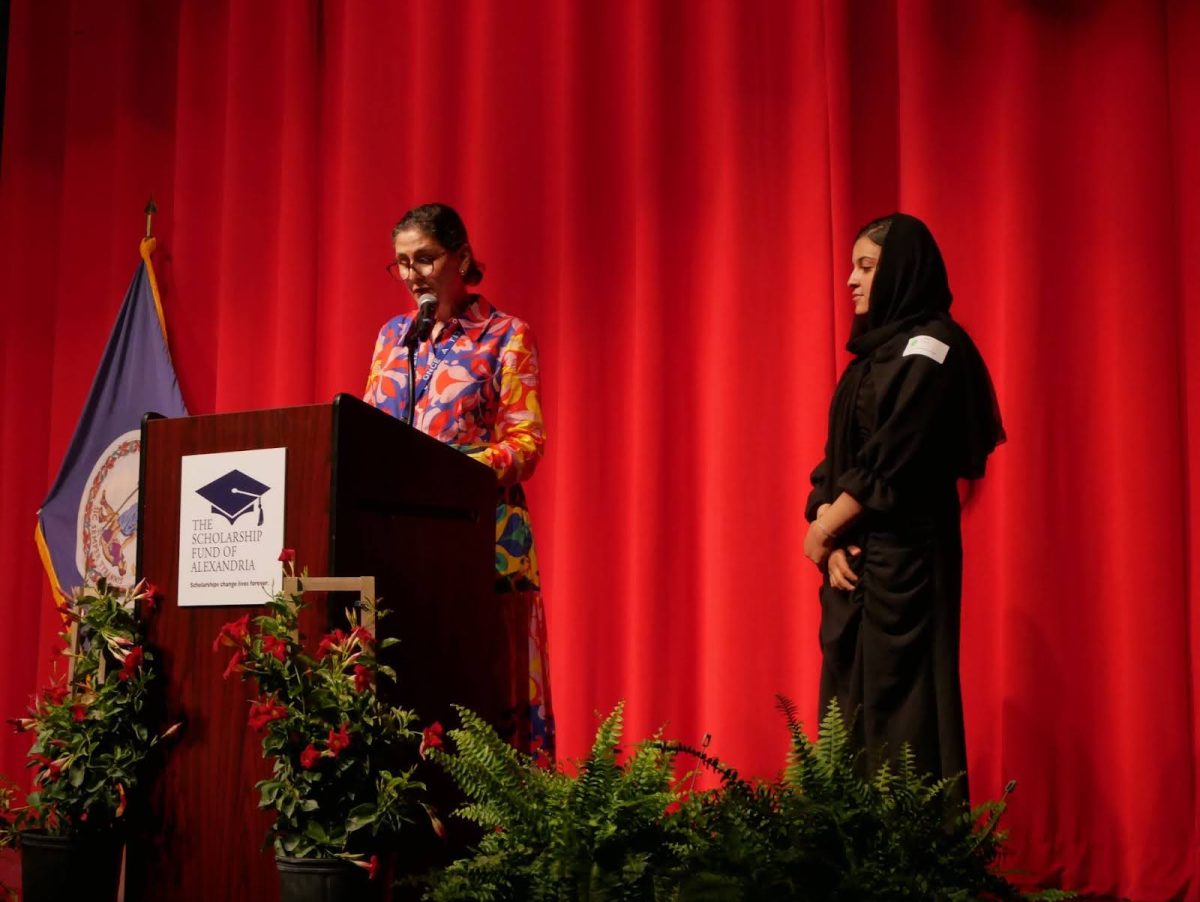 Jasmine Milone (left) introduces Zahra Rahimi (right) to the stage.