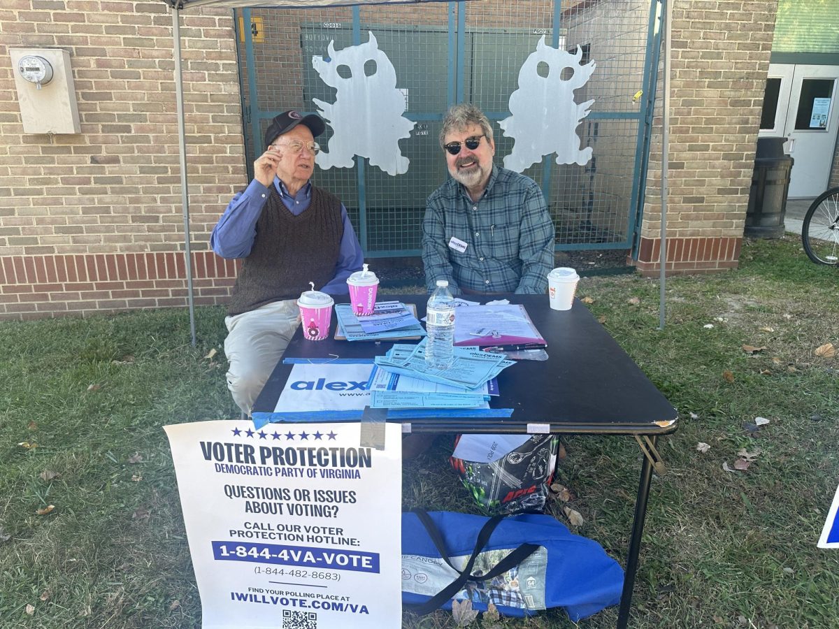 Sam Ulm and Peter Pavilionis tend to the Alexandria Democratic Committee Stand.  