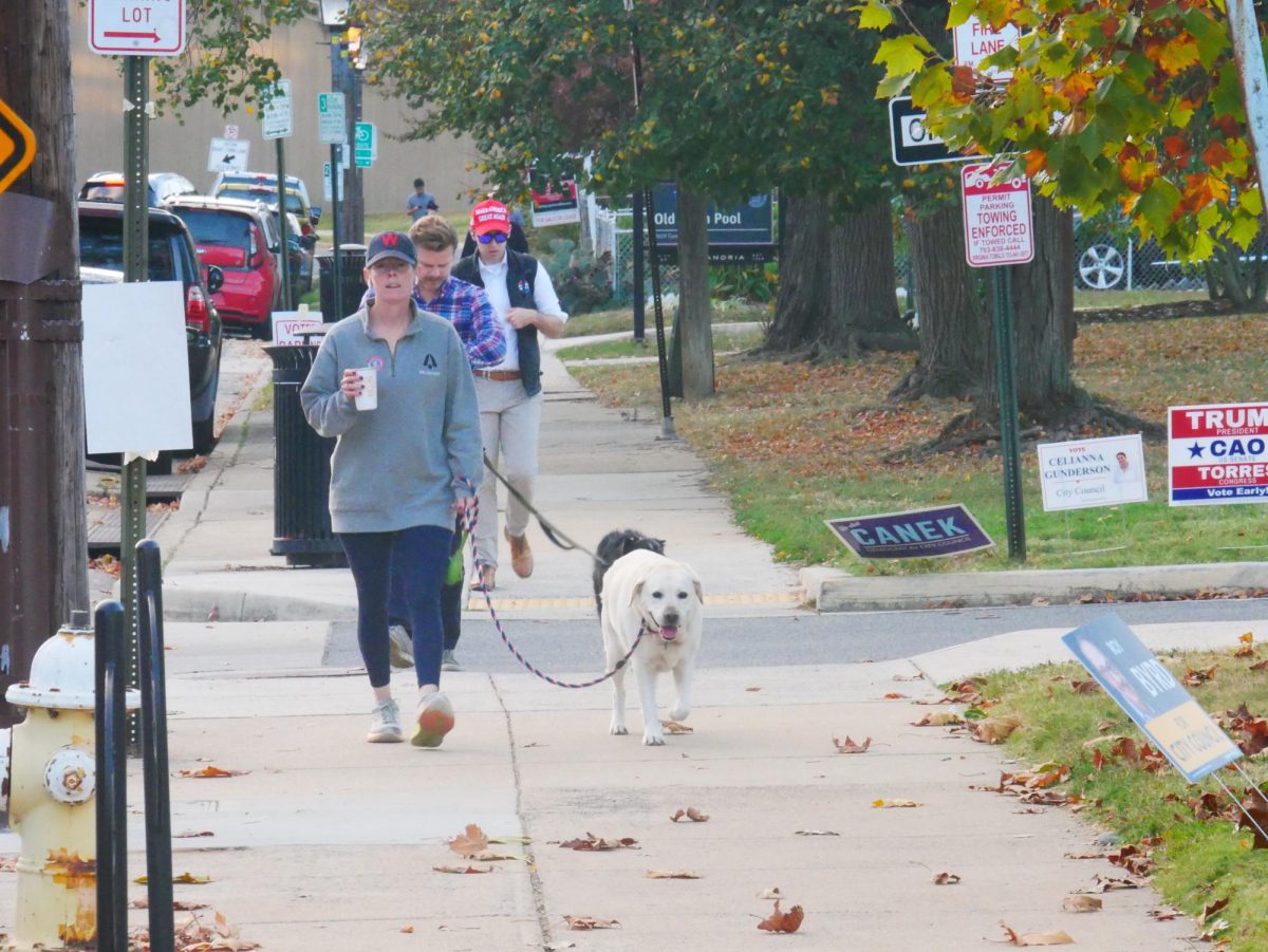 Voters, including Jon Danilowicz in the back, walk outside the Durant Center voting precinct. Danilowicz, a Republican, said he doesn't think Donald J. Trump will beat Kamala Harris in Virginia, but still has hope for local Republicans and independents.