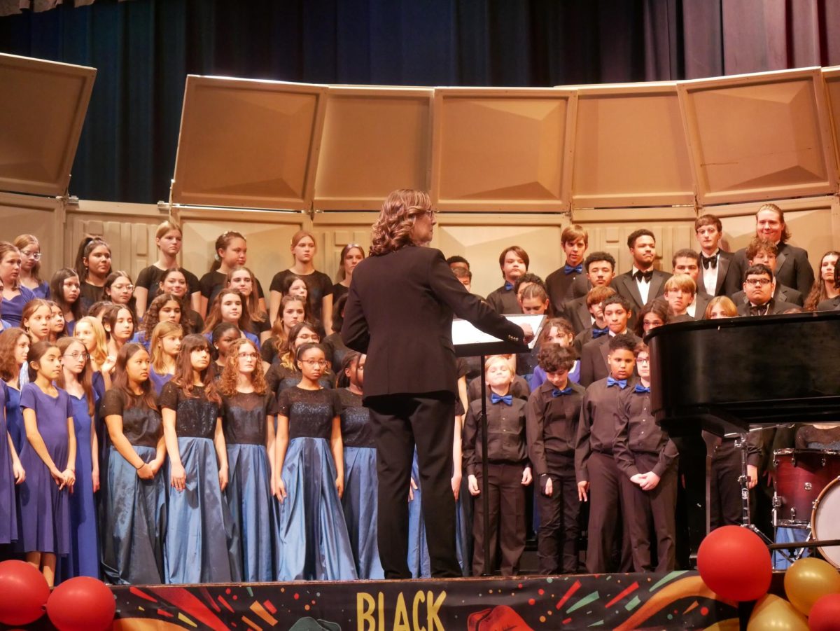 Jessica Sayler conducts the combined choirs finale, a performance of "Yo Vivo Cantando" by the Francis C. Hammond and George Washington middle schools choirs and the Alexandria City High School choir.