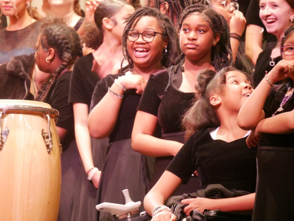 Members of the Francis C. Hammond Middle School choir share a laugh after singing 'Yo Vivo Cantando!" in the finale. 