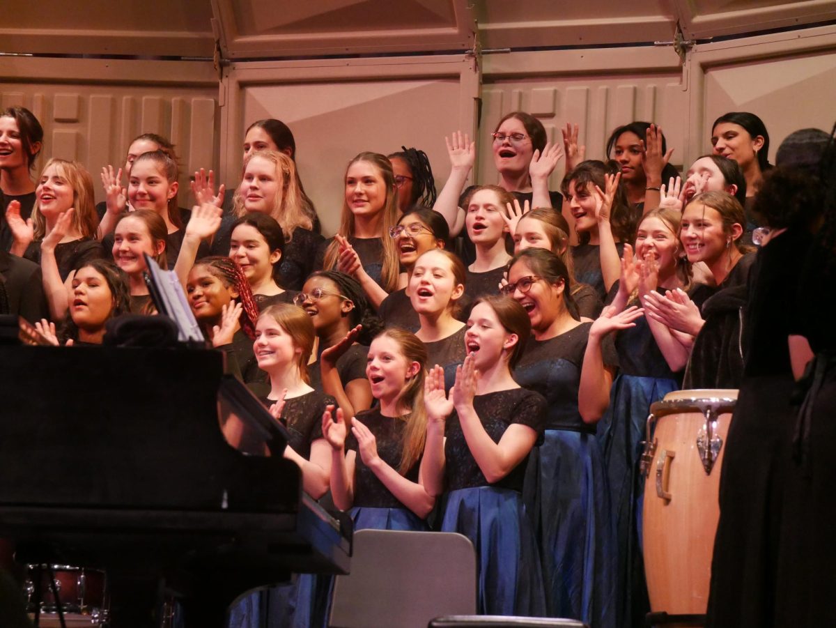 Members of the Alexandria City High School choir applaud their conductor, Theodore Thorpe III, after the concert finale. 