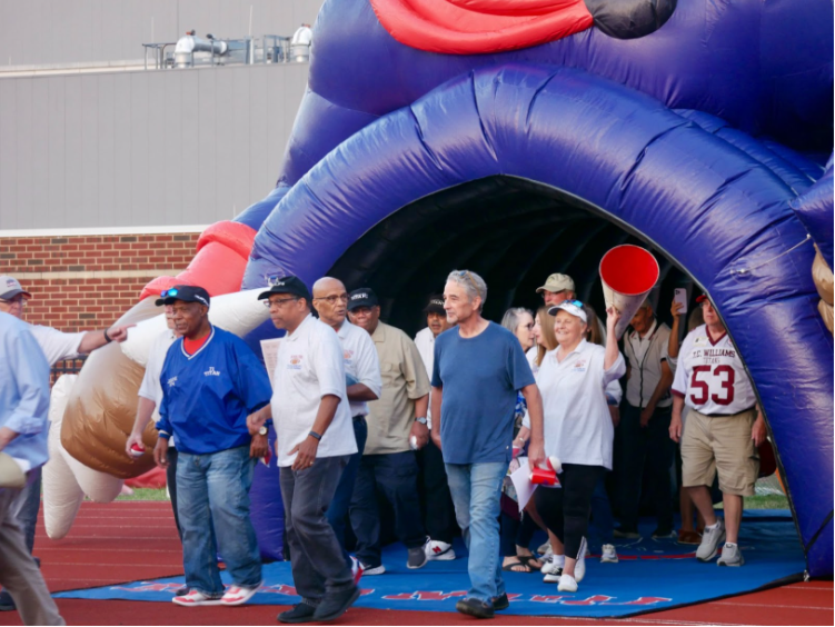 Players, cheerleaders, and coaches of the 1971 championship team walk out onto the field. (Gemma Pianesi)