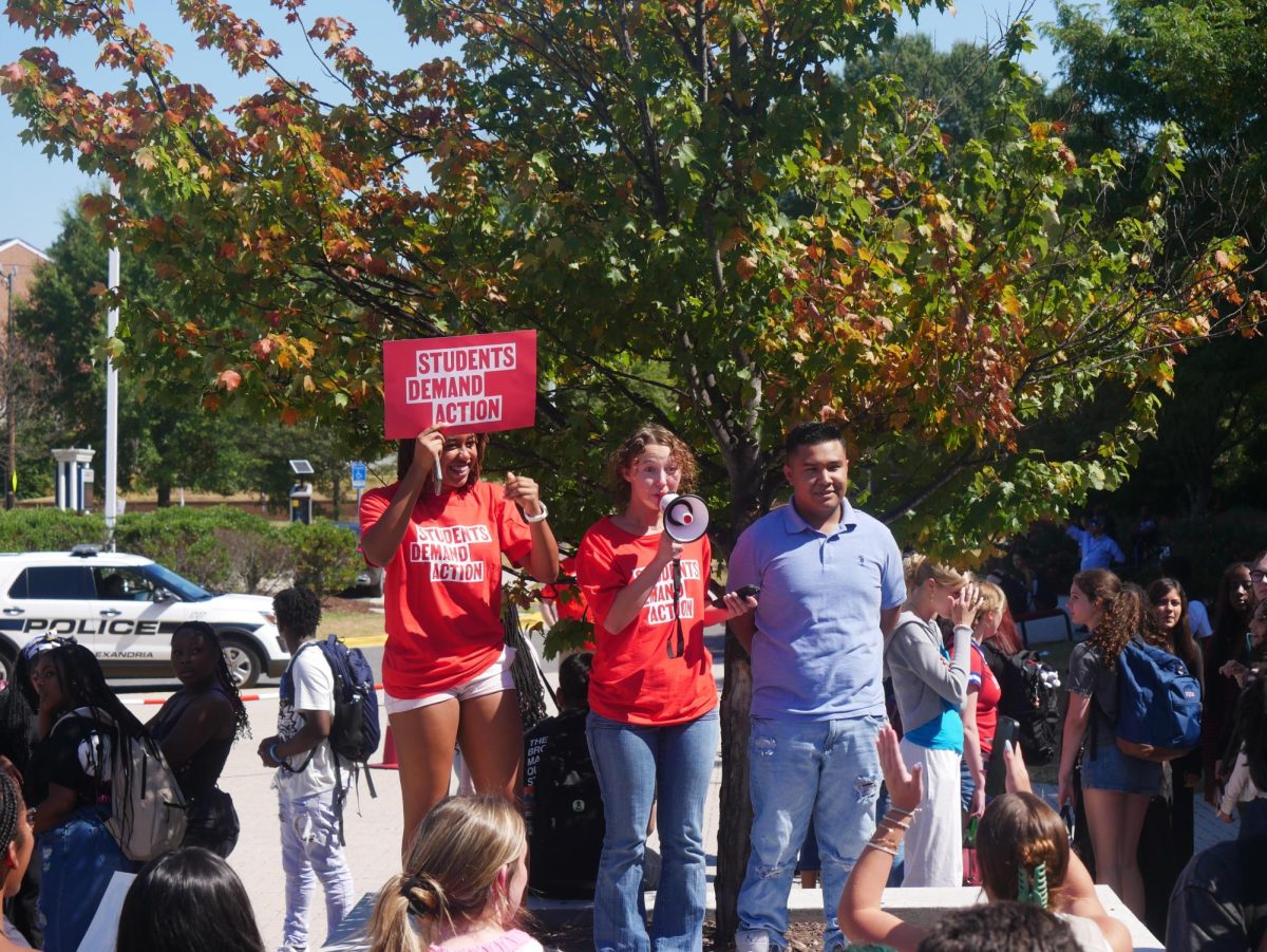 Students Demand Action leaders Zaria Edwards (left) and Natalie Cavender (middle) address the crowd at King St., along with School Board student representative Darwin Flores Salazar. 