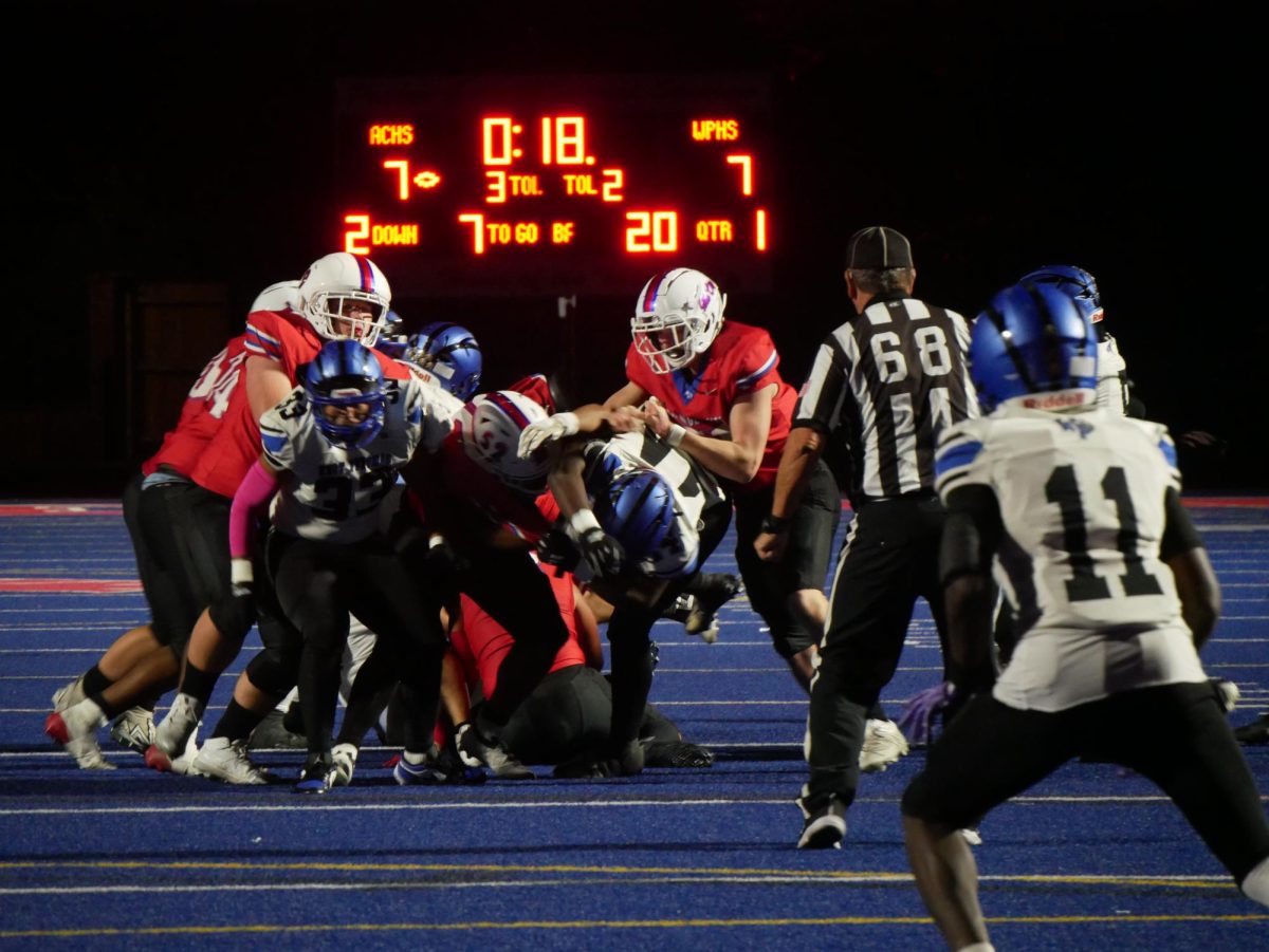 Titans tussle with Wolverines during second down of the first quarter.