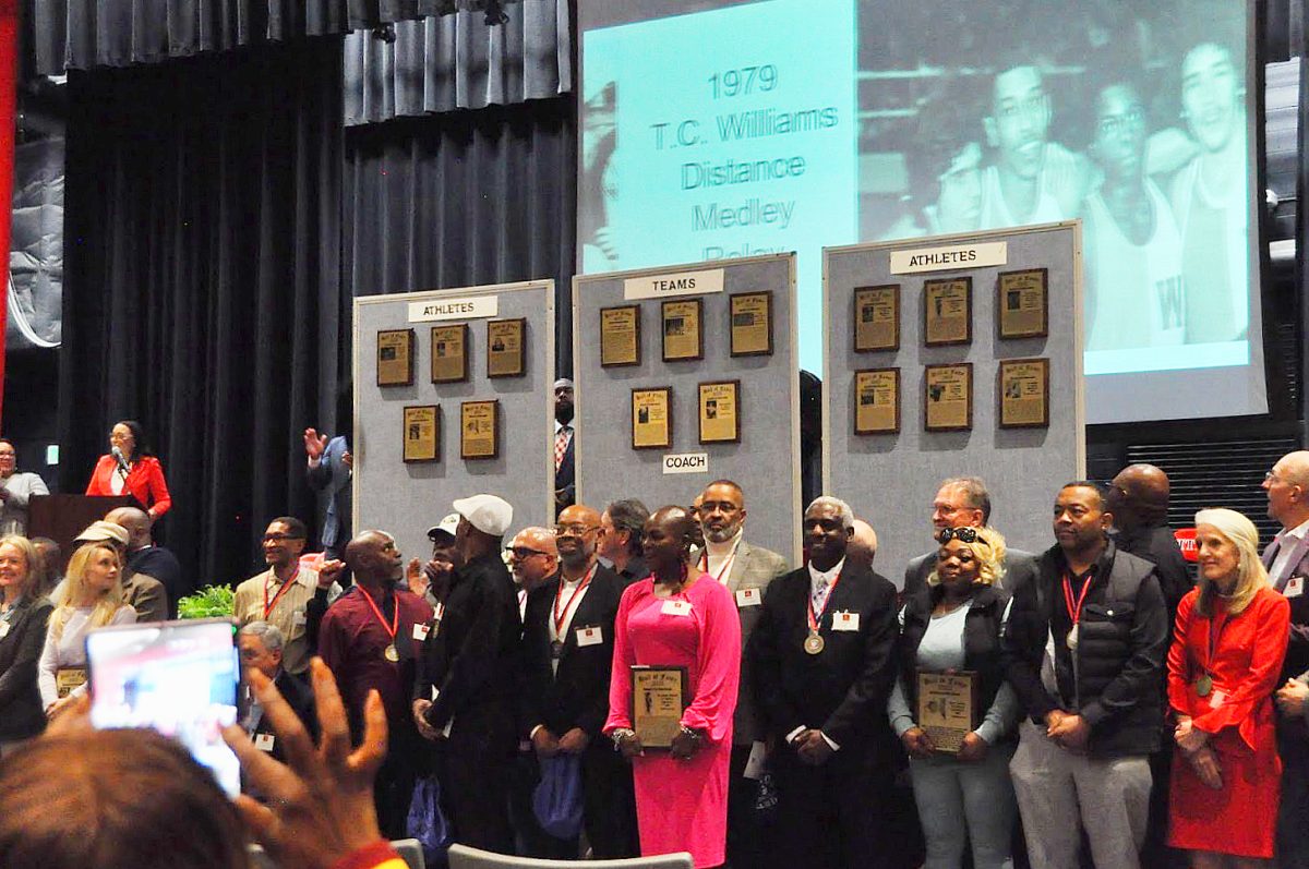 Hall of Fame inductees pose for photo in front of new plaques.