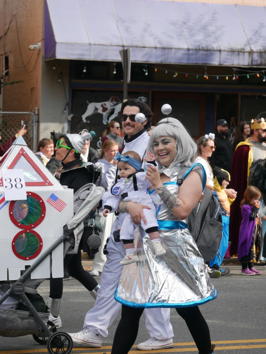 One family participates in the stroller competition, dressed as astronauts and an alien.