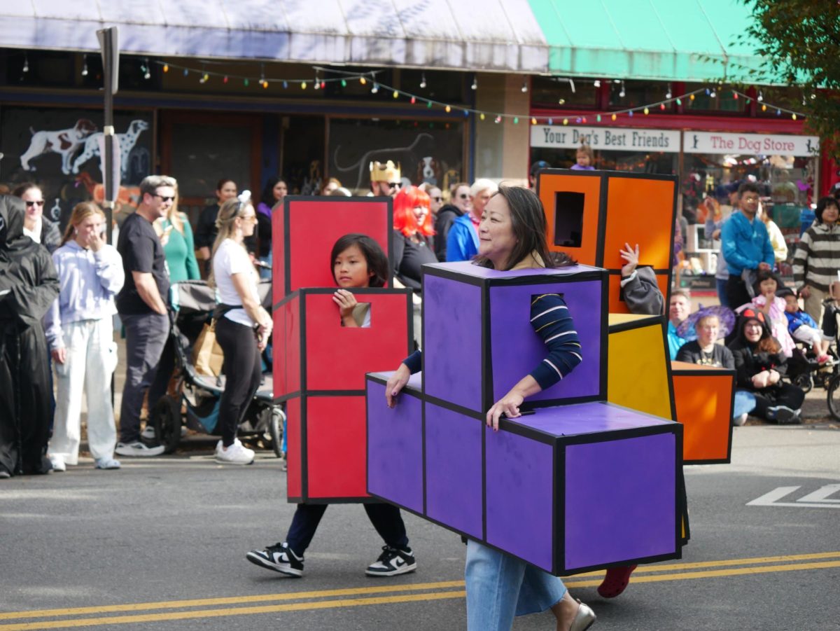 A family walks as vibrant pieces of a Tetris game, popular in the late 1980s.