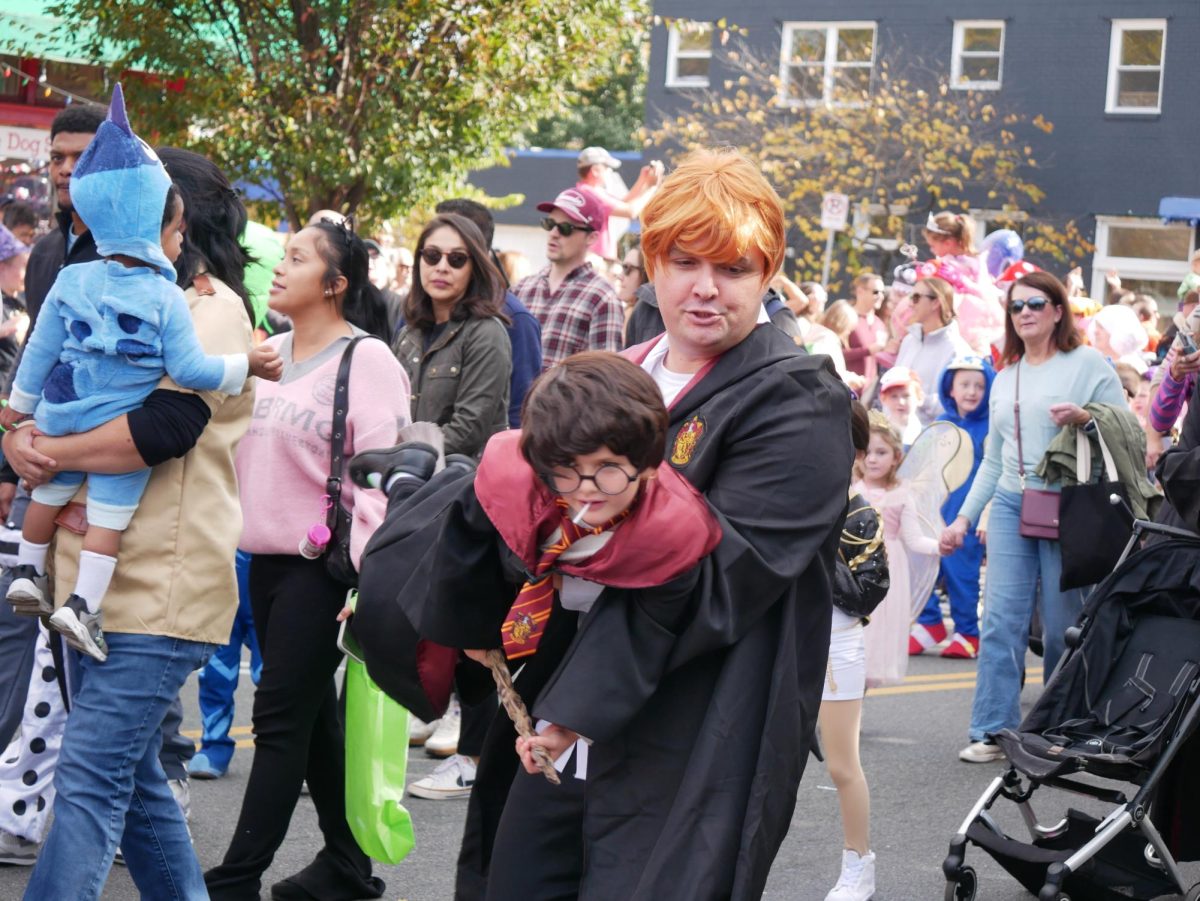 A father and son experience the parade together, both dressed as characters from JK Rowling's "Harry Potter."