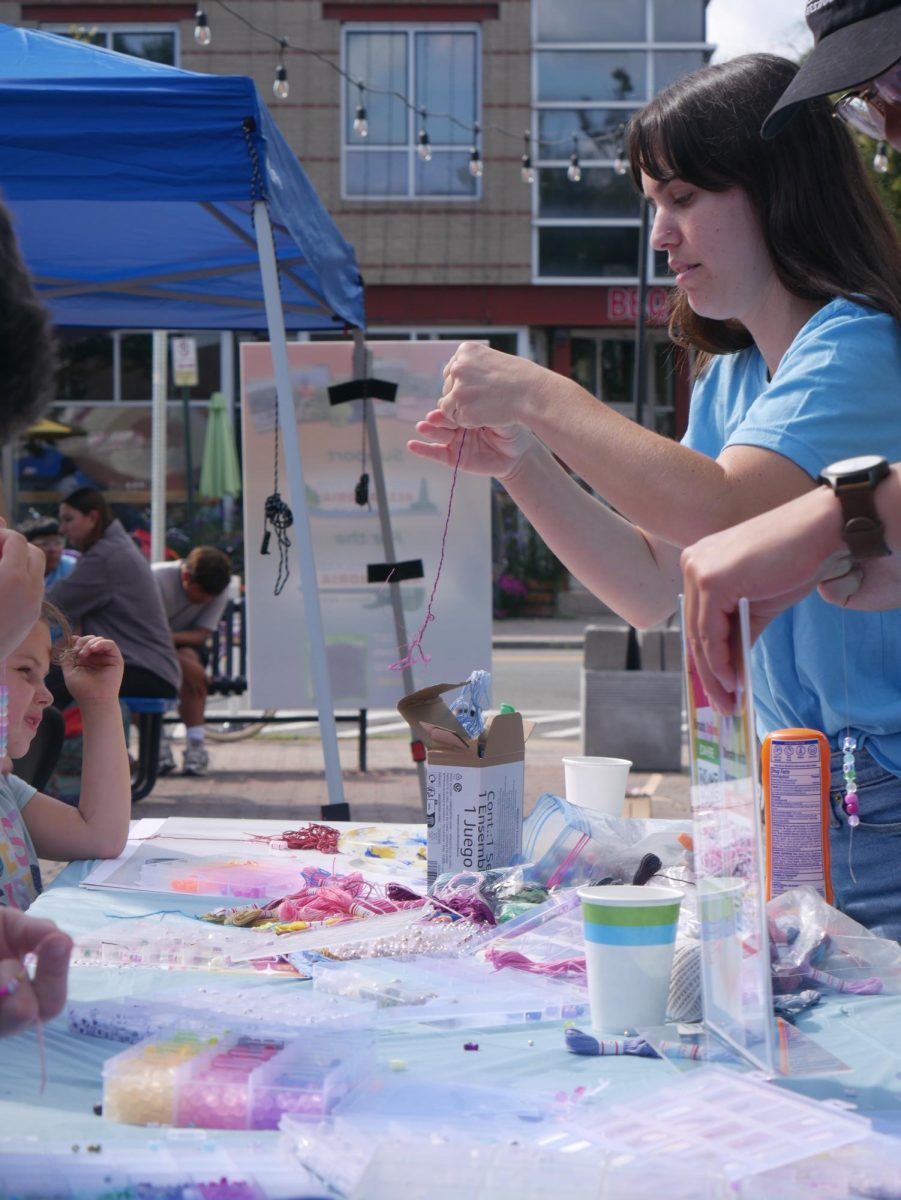 Members of the Wilderness Kids organization making bracelets with the community.