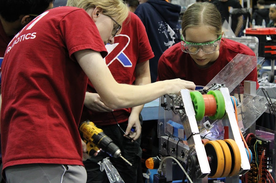 Sophomore June Gunter, sophomore Fin Hendrixson, junior Thomas Burks and junior Naematullah work on their robot to make it competition ready!