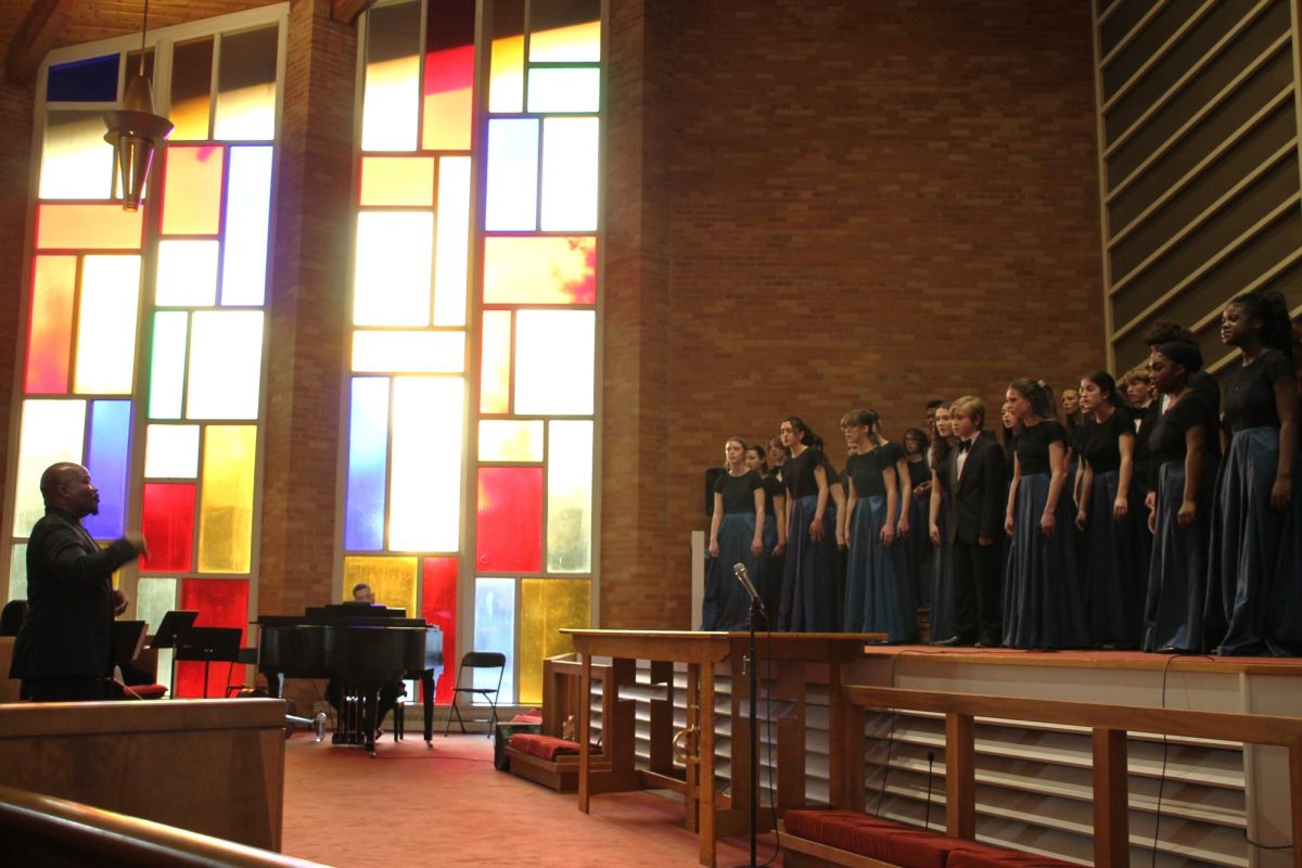 Theodore Thorpe III conducts the ACHS choir while performing on the chancel.
