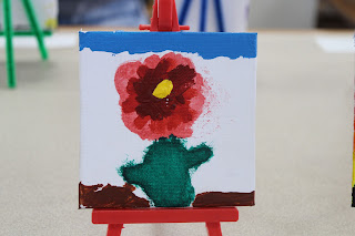 An untitled painting features a flower in bloom, painted by young community member, Lydia Duncan.