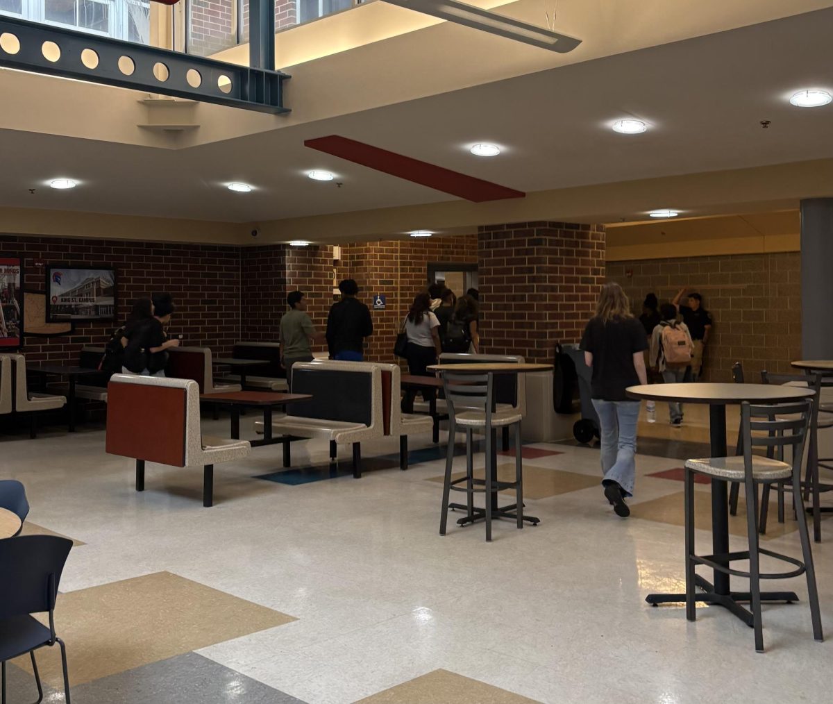Students are leaving the cafeteria to go back to class after lunch has ended.